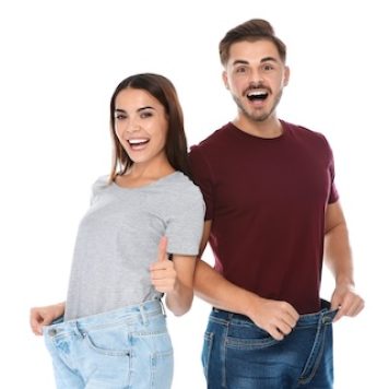 Fit people in oversized jeans on white background. Weight loss